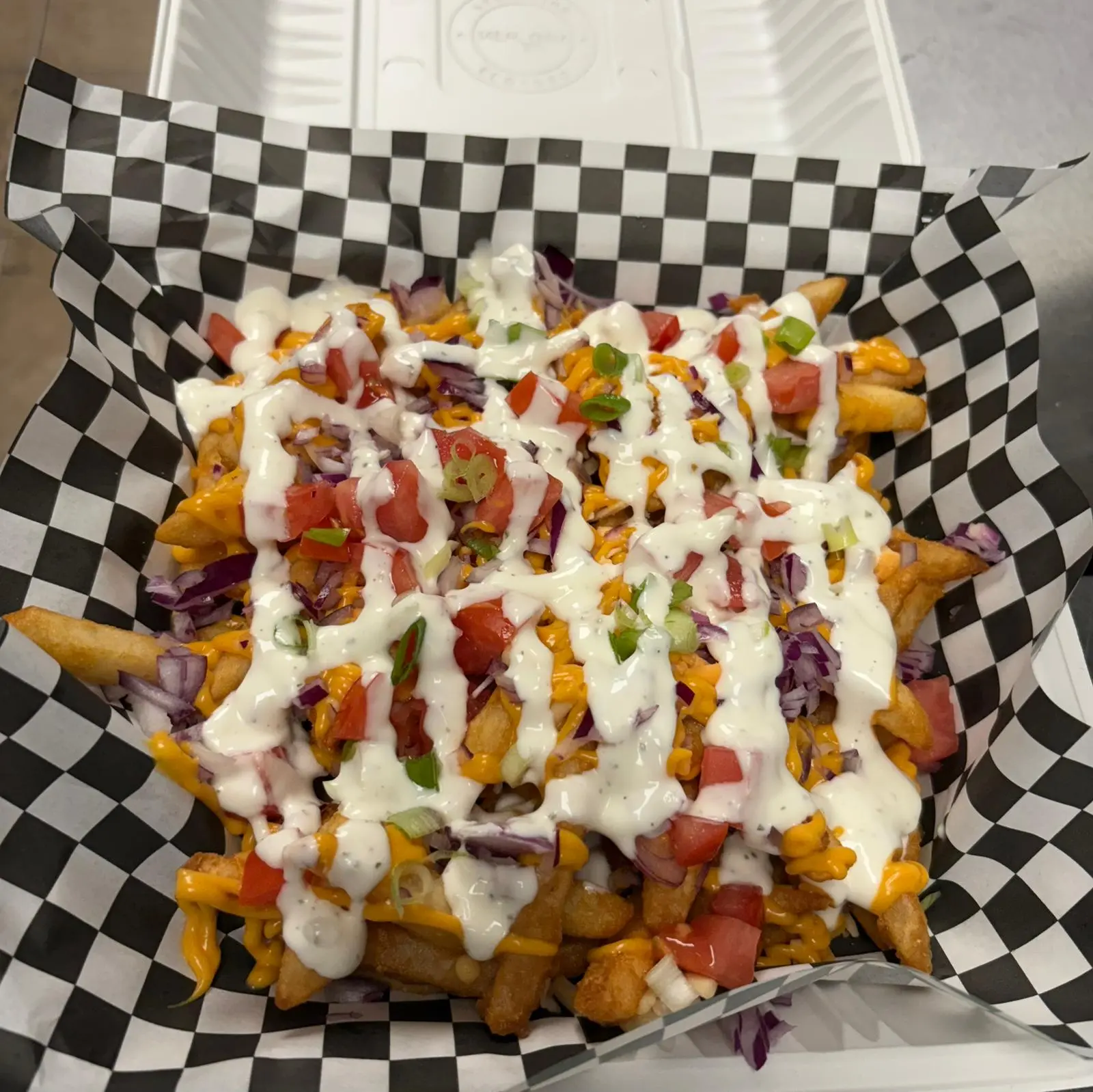 Loaded fries topped with sauces and garnishes at Wing Crafters London Ontario